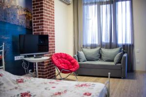 ein Wohnzimmer mit einem Sofa und einem TV in der Unterkunft Apartment on Takaishvili in Batumi