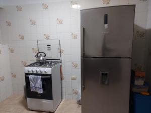 a kitchen with a stainless steel refrigerator and a stove at KUSIHaus in Lima +10 photos