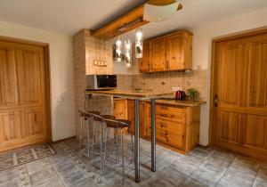 a kitchen with wooden cabinets and bar stools at ``Art home Baroni`` in Cēsis +12 photos