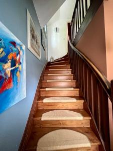 a stairway with wooden steps and a painting on the wall at Kleine Landhaus-Perle am Schlosspark in Eutin