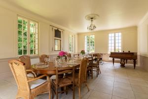 a dining room with a table and a piano at Le Domaine de Flancourt - Échappée Belle en tribu in Flancourt-Crescy-en-Roumois