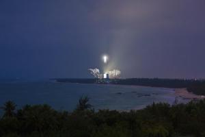 an island in the water at night with a light at Hilton Wenchang in Wenchang