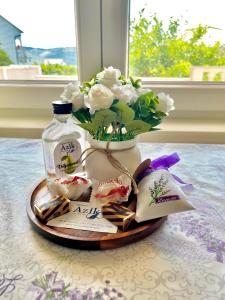 a vase filled with flowers and a bottle of milk at Apartmani Azik in Lopar +16 photos