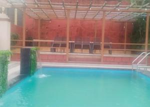 パンチガニにあるLuxurious Shivanya Palace 7BHKの空のスイミングプール(椅子、テーブル付)
