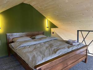 Family cottage في يابلونيتسيا: سرير في غرفة بجدار أخضر