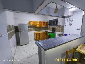 a kitchen with a counter top and a refrigerator at شقة في كمباوند النورس علي البحر in Ismailia