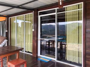 a room with a balcony with a table and a view at Barn Hills in Ella