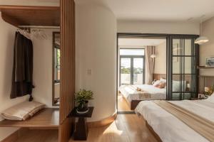 ダラットにあるAlmira Home Da Latのベッド2台と窓のある寝室