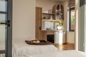 ダラットにあるAlmira Home Da Latのベッド2台とキッチンが備わる客室です。