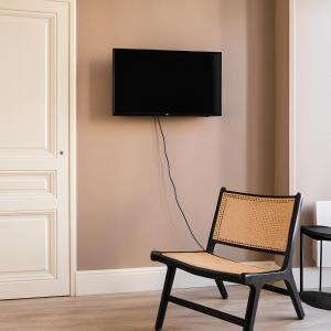 リヨンにあるSuite Pianoの壁にテレビが付いた部屋の椅子