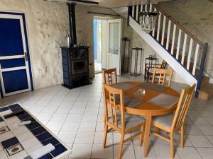 a dining room with a table and chairs and a staircase at Le Gîte Saint Girons in Saint-Girons-dʼAiguevives