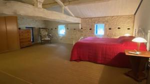 a bedroom with a red bed in a room at Le Gîte Saint Girons in Saint-Girons-dʼAiguevives