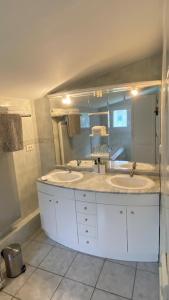 a bathroom with two sinks and a large mirror at Le Gîte Saint Girons in Saint-Girons-dʼAiguevives