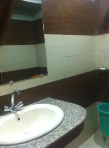 une salle de bain avec un lavabo et un miroir dans l'établissement Hotel DM Residency, à Dargai