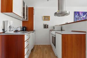 a kitchen with white appliances and wooden cabinets at LK1474-Lokken-Vrenstedvej-3-E in Løkken +12 photos