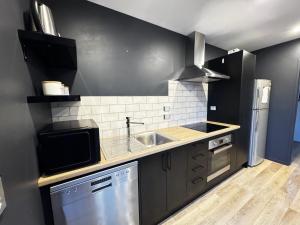 Queenstown AirportにあるMeraki Guesthouseのシンクとコンロのあるキッチン