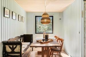 a dining room with a table and a window at LK2096-Lokken-Raevevej-4 in Løkken +10 photos