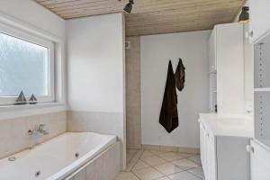 a white bathroom with a tub and a sink at LK1802-Lokken-Septembervej-2-b in Løkken +15 photos