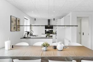 una cucina bianca con tavolo e sedie in legno di LK2106-Lokken-Norgesvej-18 a Løkken