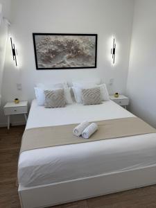 ein Schlafzimmer mit einem großen weißen Bett mit zwei Kissen in der Unterkunft Le charme aux portes de Paris in Bonneuil-sur-Marne