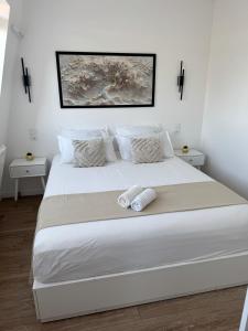 ein weißes Bett mit zwei weißen Kissen darauf in der Unterkunft Le charme aux portes de Paris in Bonneuil-sur-Marne