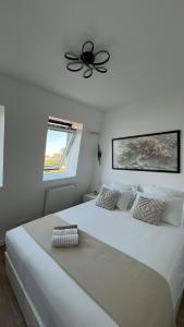 ein Schlafzimmer mit einem großen weißen Bett mit Deckenventilator in der Unterkunft Le charme aux portes de Paris in Bonneuil-sur-Marne