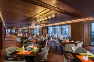Un restaurante con mesas y sillas de madera y un escritorio. en Holiday Inn Xingtai Quancheng by IHG, en Xingtai