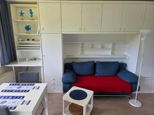 a living room with a red couch and white cabinets at PEMATRA Ferienwohnungen Ostseestrasse 2 in Travemünde