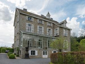 a large brick building with windows on the side of it at Beautiful manor house in a park near Rochefort in Forrières