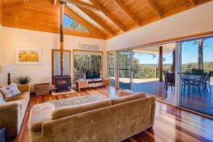 un soggiorno con divano, camino e porte in vetro di Burwood Bush House - Close to Wineries and Beach a Yallingup Siding