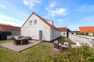 una casa bianca con un patio e alcune sedie di LK551-Lokken-Houmannsvej-17 a Løkken