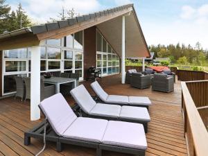 a deck with white chairs and a pavilion at 4 star holiday home in Skals in Skals +35 photos