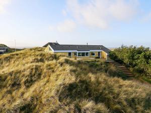 a house on the top of a grassy hill at 9 person holiday home in Saltum in Saltum