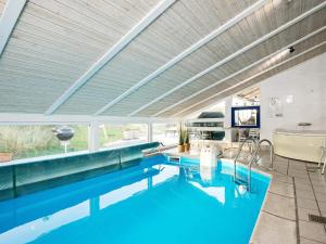 a bathroom with a large pool with a tub and a sink at 9 person holiday home in Saltum in Saltum +28 photos
