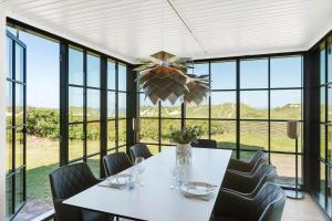 Un comedor con mesa y sillas y ventanas. en LK2042-Lokken-Ved-Vandtarnet-4, en Løkken