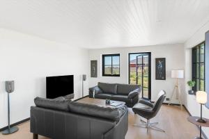 Una sala de estar con un sofá de cuero y un televisor. en LK2042-Lokken-Ved-Vandtarnet-4, en Løkken