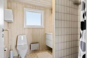 a bathroom with a toilet and a window at LK1985-Lokken-Monasvej-24 in Løkken +13 photos