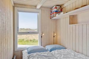 a small bedroom with a bed and a window at LK1985-Lokken-Monasvej-24 in Løkken