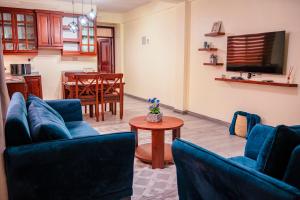 un soggiorno con due divani blu e un tavolo di Maftah's Plaza a Bagamoyo