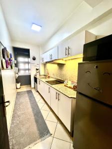 a kitchen with white cabinets and a refrigerator at Appartement B living in Agadir