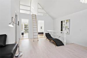 a white living room with a black couch and a ladder at LK1106-Lokken-Strandparken-32 in Løkken