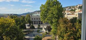 vistas a un edificio de una ciudad con árboles en Essenza Home, Design alle porte della città, en Trieste