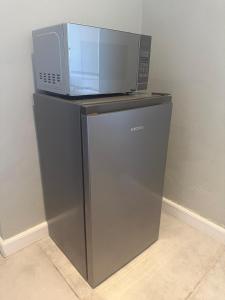 a microwave sitting on top of a refrigerator at Kénōsis Guestfarm - Room 1 in Springbok