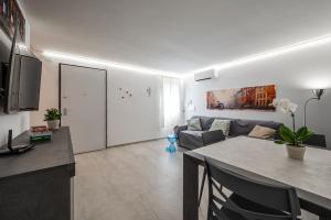Una cocina y una sala de estar con una mesa y un sofá. en La Maisonette del Crist0, en Sorbara