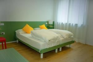 a bed with yellow and white pillows on it at Countryhouse Verso in Rovereto