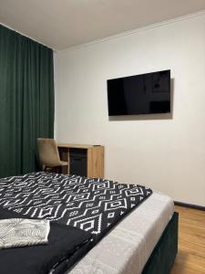a bedroom with a bed and a television on the wall at Затишні апартаменти для Вас in Uzhhorod