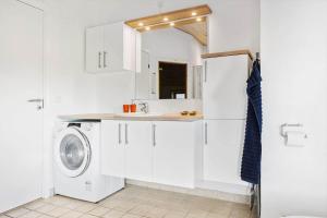 a white kitchen with a washing machine and a sink at LK537-Lokken-Mievej-20 in Løkken