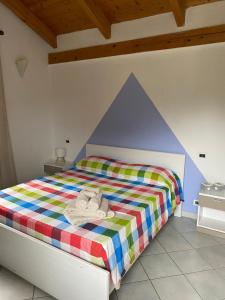 a bedroom with a bed with a colorful comforter at La Cà di Carol in Tollegno