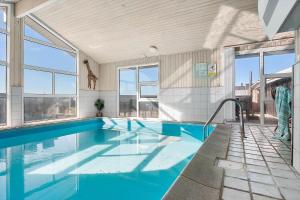 a swimming pool with blue water in a building at LK2129-Lokken-Diget-18 in Løkken