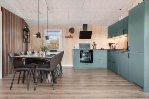 a kitchen with a table and some blue cabinets at LK2129-Lokken-Diget-18 in Løkken